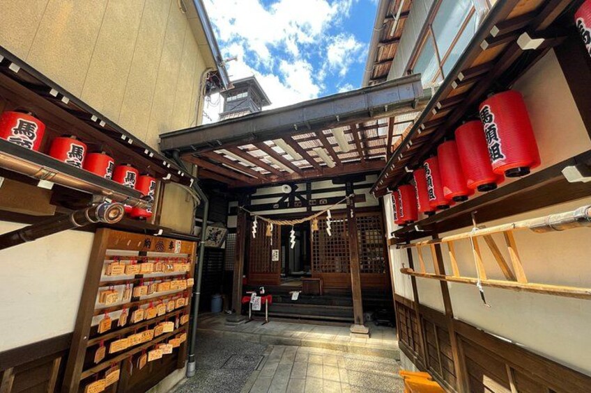 Ein traditioneller japanischer Gang mit Holzbauten, roten Laternen und Regalen voller verpackter Waren. 2