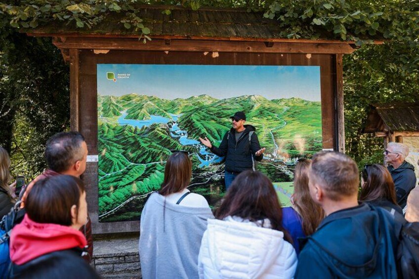 A person presenting a map to an audience outdoors. 1