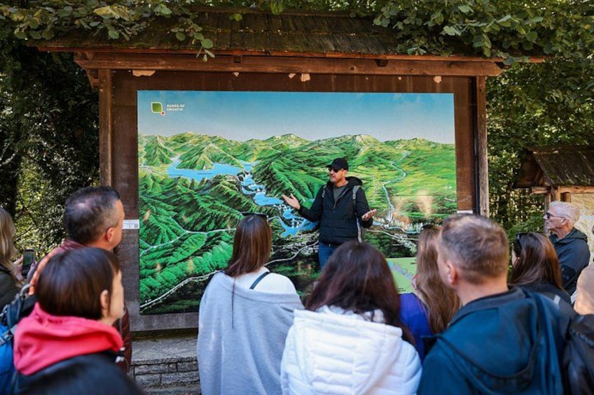 A person giving a presentation to a group of people in front of a large map. 1