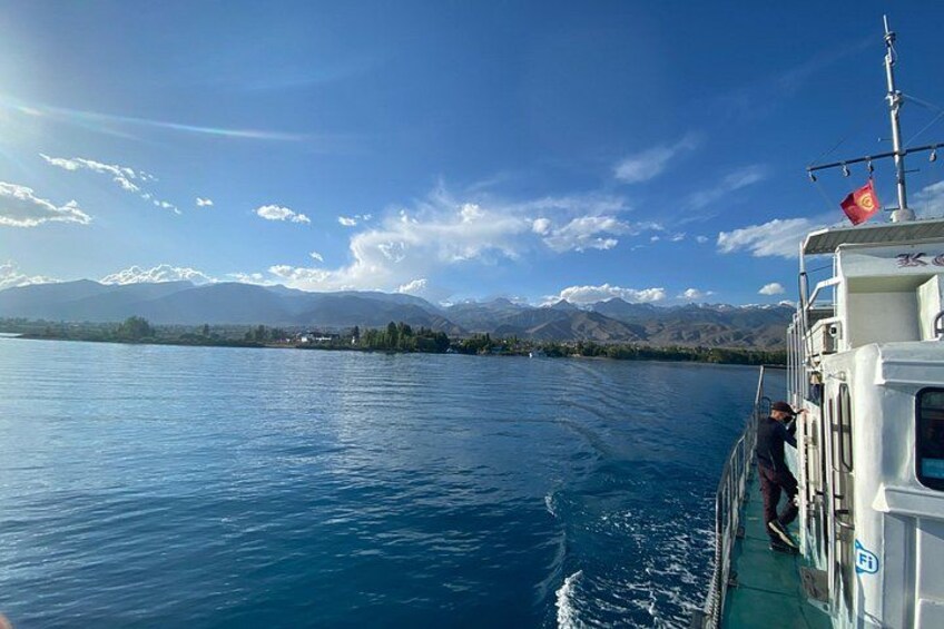 A boat on a calm lake with mountains in the background. 3
