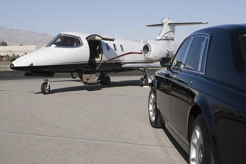 A private jet parked on a tarmac with a luxury car beside it. 4