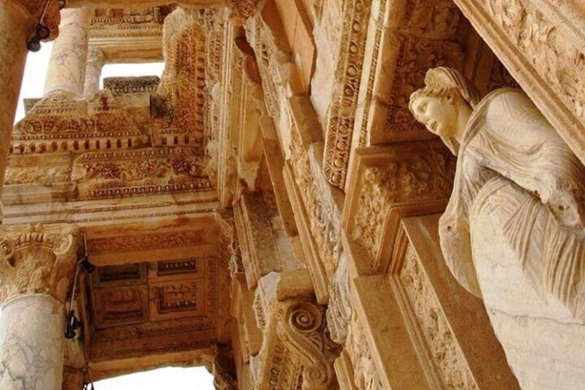 A detailed stone carving of a figure in a classical architectural setting. 2