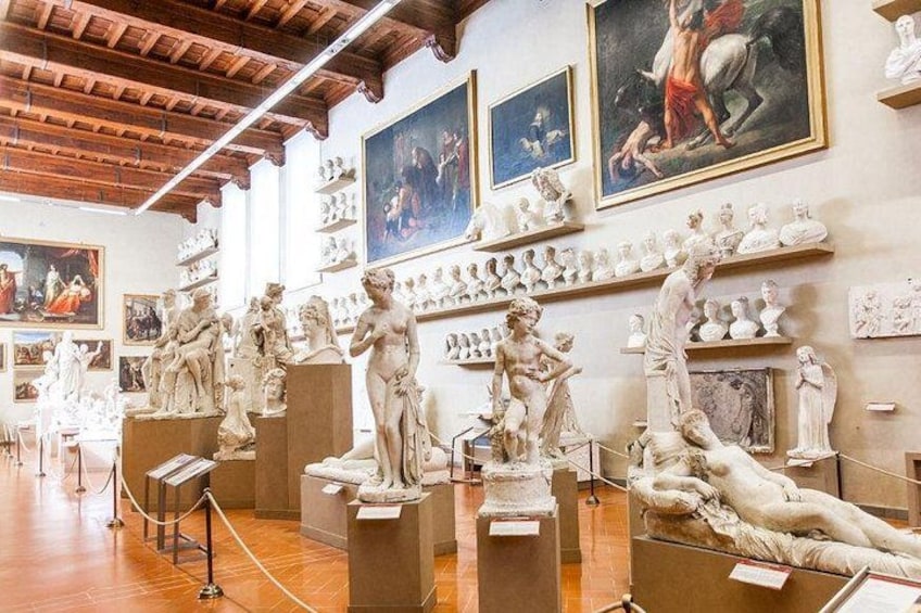 A museum with marble sculptures and paintings on the walls. 3