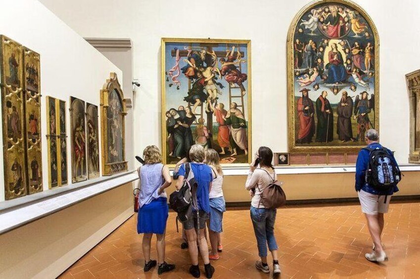 Un gruppo di persone che osserva dei dipinti in un museo. 3