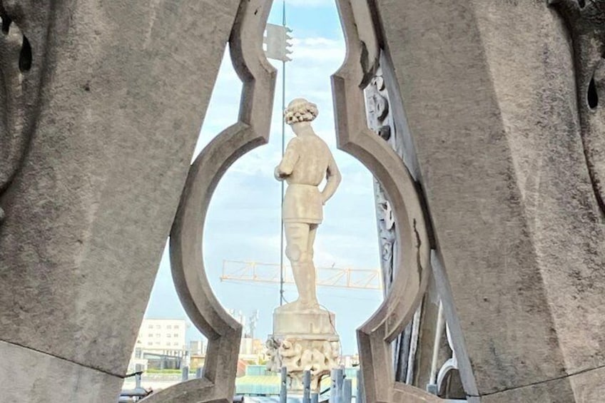 A statue within a stone archway, with a construction site visible in the background. 4