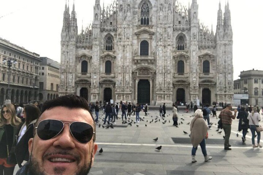 A historic cathedral with intricate architecture, a crowd of people, and pigeons on the ground. 3