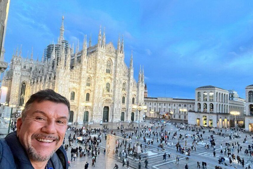 A historic cathedral with intricate architecture, a bustling square, and a modern building in the background. 1