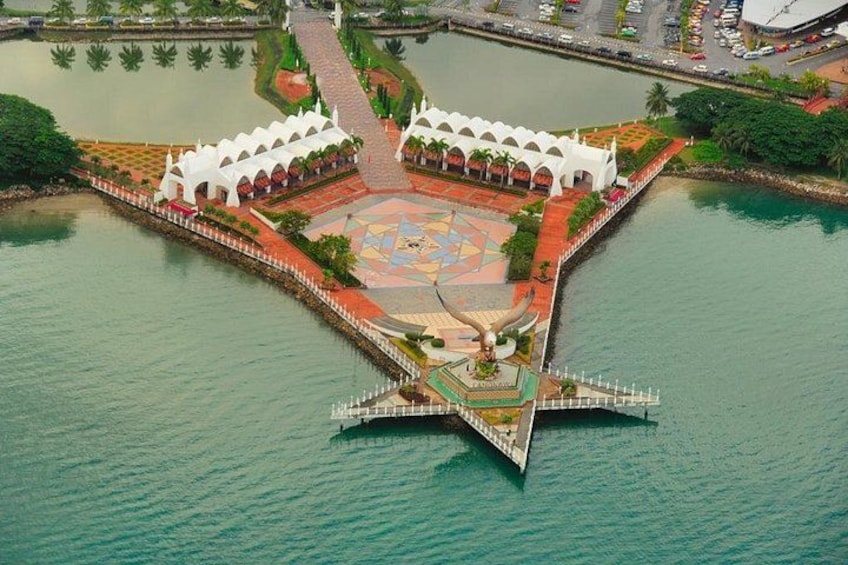 Un grand bâtiment blanc doté d’une cour intérieure, entouré d’eau. 4
