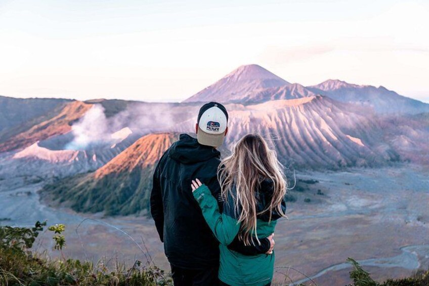 A couple embracing with a volcanic landscape in the background. 4
