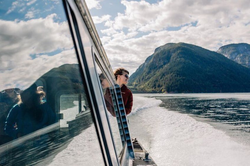 A boat on a lake with mountains in the background. 3