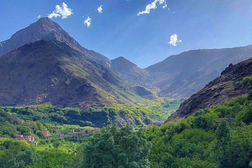 Eine gebirgige Landschaft mit einem Tal, dichtem Grün und blauem Himmel. 4