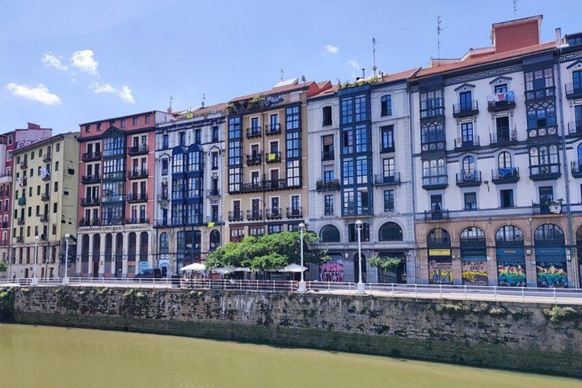 A row of colorful buildings along a riverbank. 2