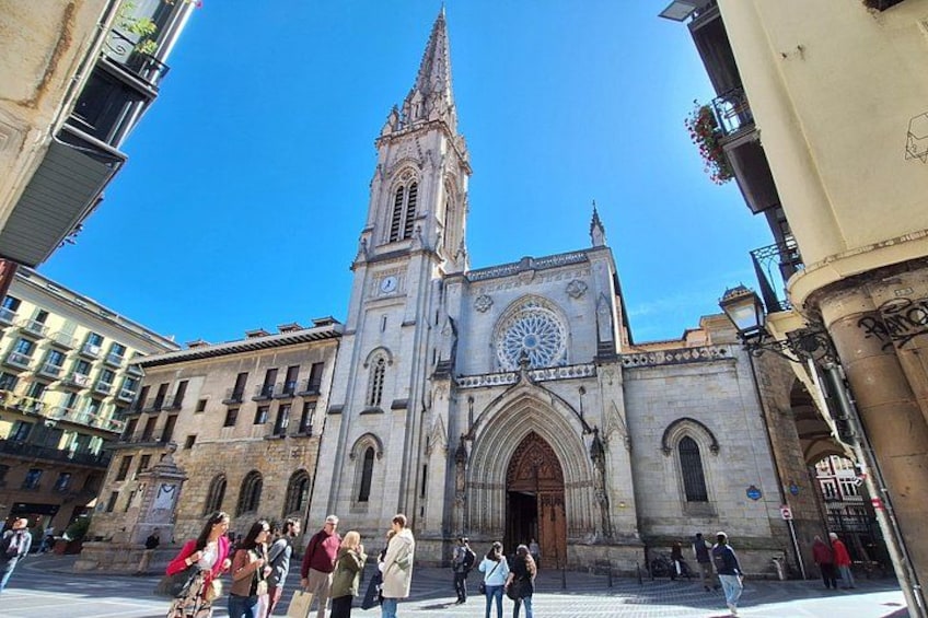 A historic church with a tall spire and a large circular stained glass window. 5