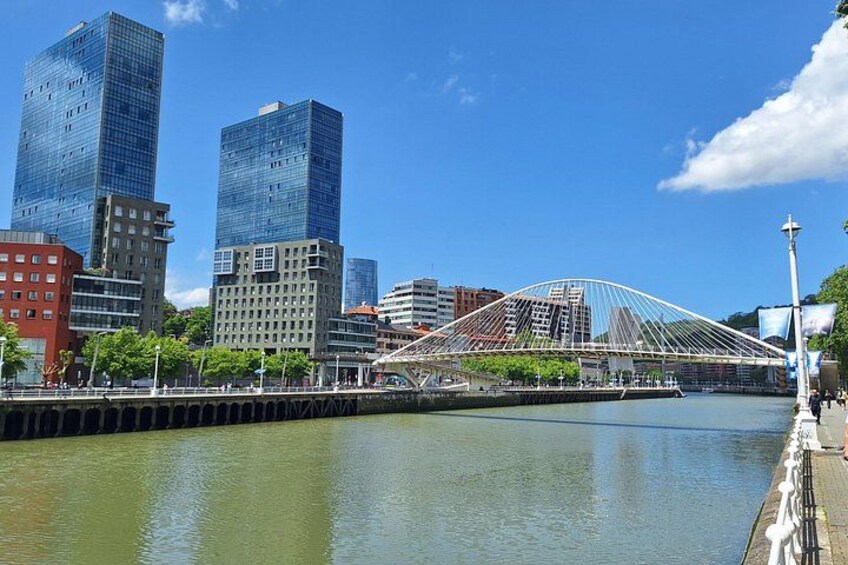 A cityscape with modern skyscrapers, a river, and a distinctive bridge. 4