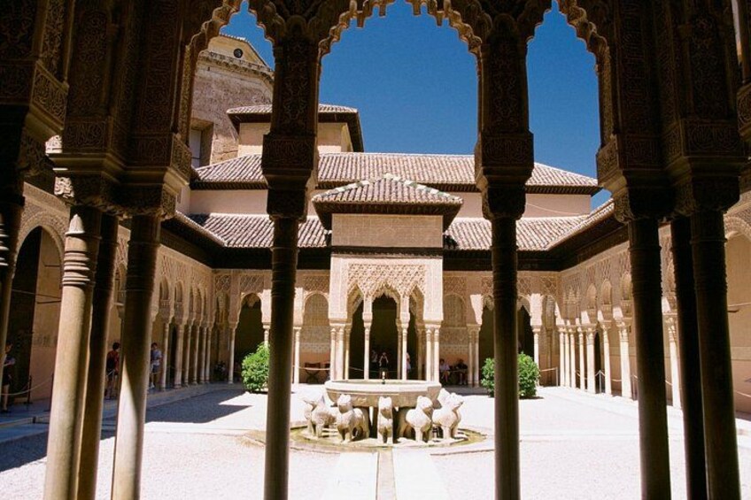 Un patio arquitectónico con arcos, columnas y una fuente. 4