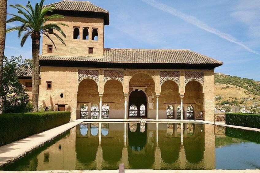 Un edificio histórico con arcos y una piscina reflectante. 5