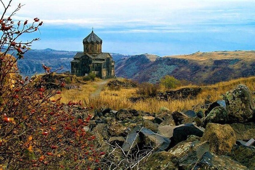 A stone church on a hill with a clear sky. 2