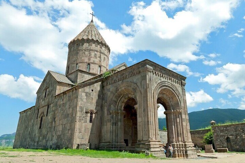 A historic stone church with a prominent dome and large arches. 3