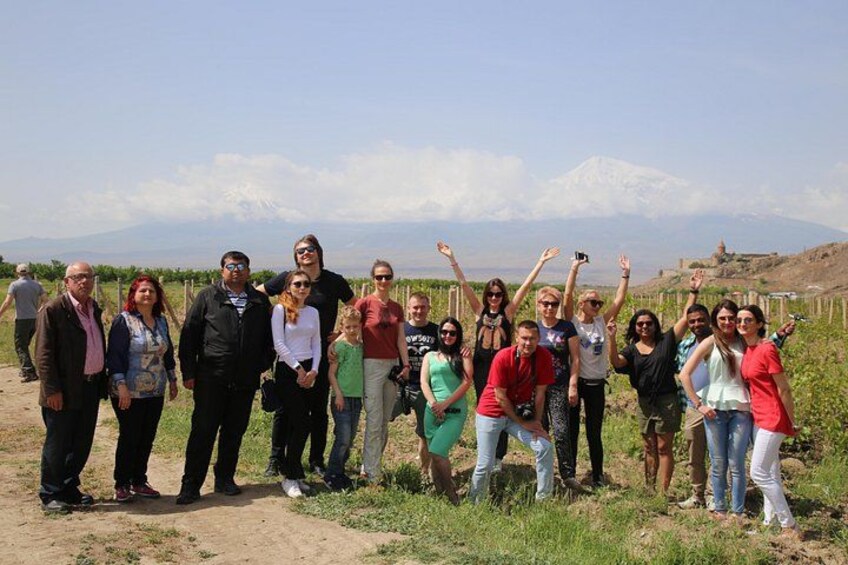 A group of people standing on a dirt path with a mountainous landscape in the background. 3