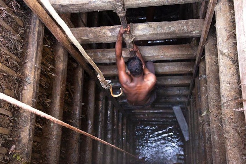 A person hanging from a rope in a narrow, wooden structure. 2