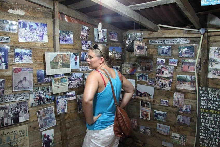 A person standing in front of a wall covered with photographs and notes. 3