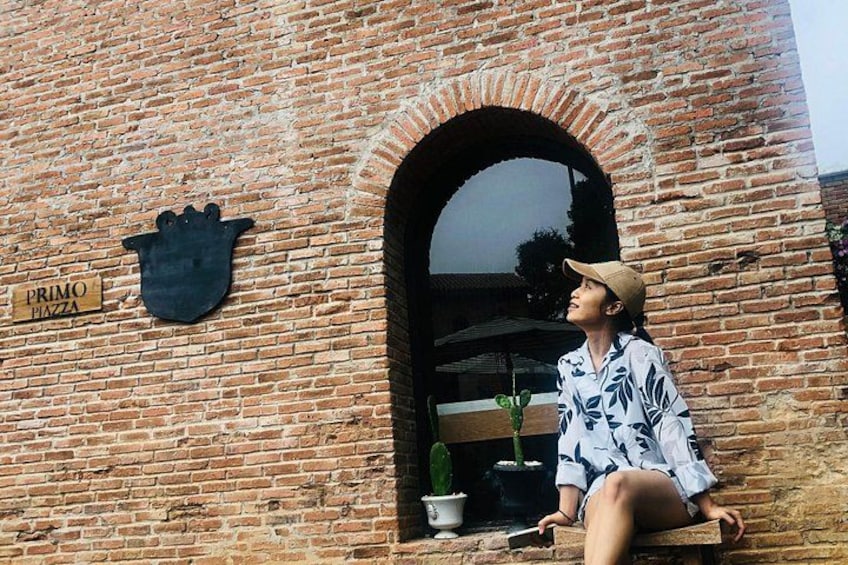 A brick building with a sign that reads 'PRIMO PIZZA' and a black hand-shaped sign. 2
