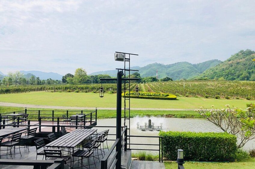 A riverside park with benches, a water feature, and a distant view of mountains. 1