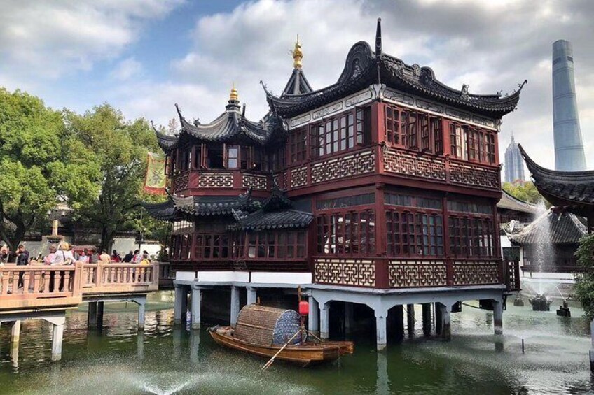 A traditional Chinese building with ornate architecture, a boat, and a modern skyscraper in the background. 4