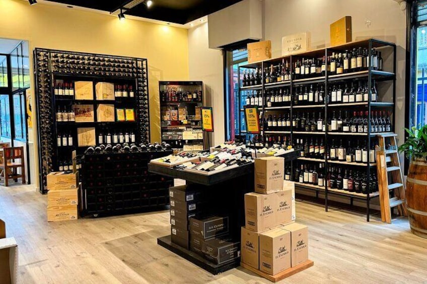 A wine store with shelves of wine bottles and boxes of wine. 3
