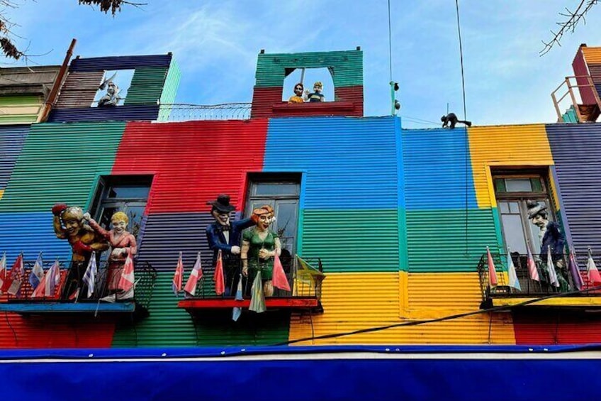 A colorful building with statues on the balconies. 1