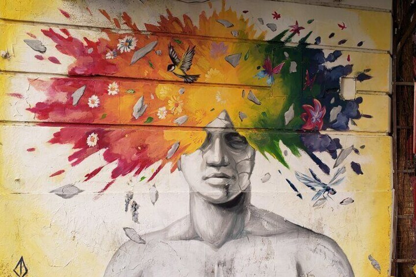 A mural with a human figure, vibrant colors, and floral patterns. 5