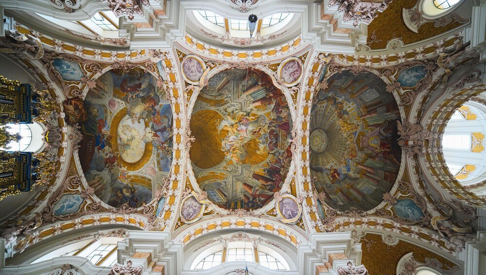 Un interior majestuoso y ricamente decorado, con frescos elaborados y detalles dorados. 2