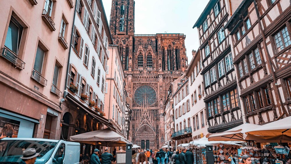 A bustling European street with historic buildings, a prominent cathedral, and outdoor cafes. 5