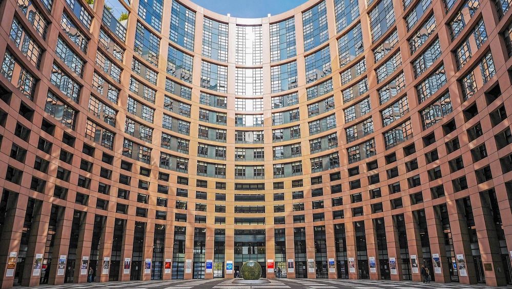A modern curved building with a central entrance and multiple floors. 2