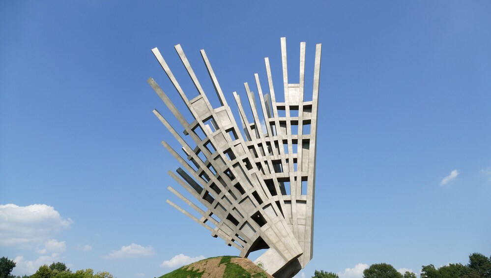 A modern sculpture with a geometric design, set against a clear blue sky. 4