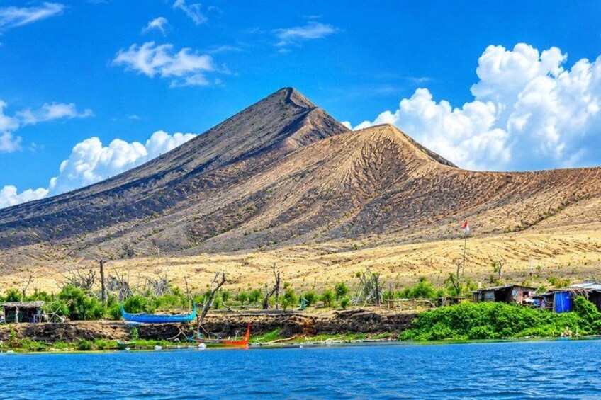 A mountain, a body of water, and a small settlement with boats. 3