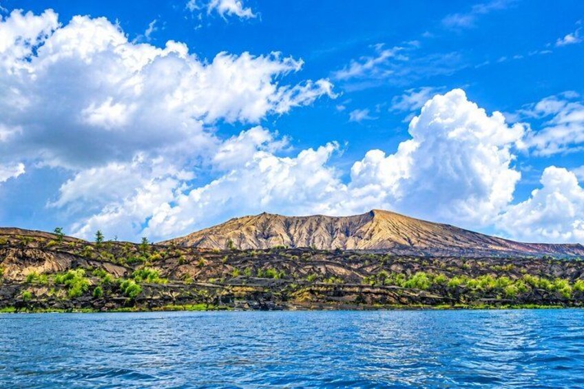 A mountain range with a clear sky and water in the foreground. 5