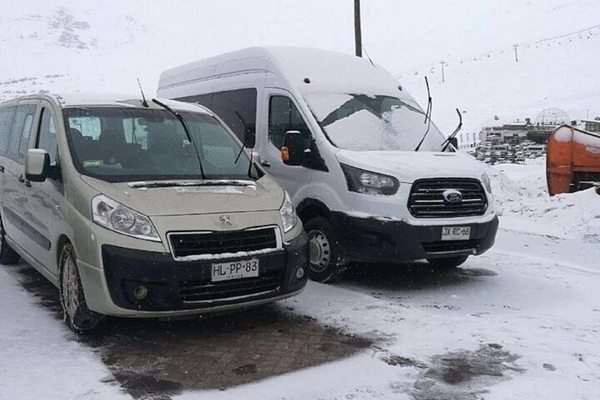 Dos vehículos estacionados sobre una superficie nevada con fondo desenfocado. 3