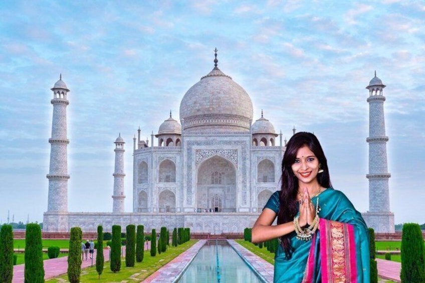 A person in traditional attire standing in front of the Taj Mahal. 2