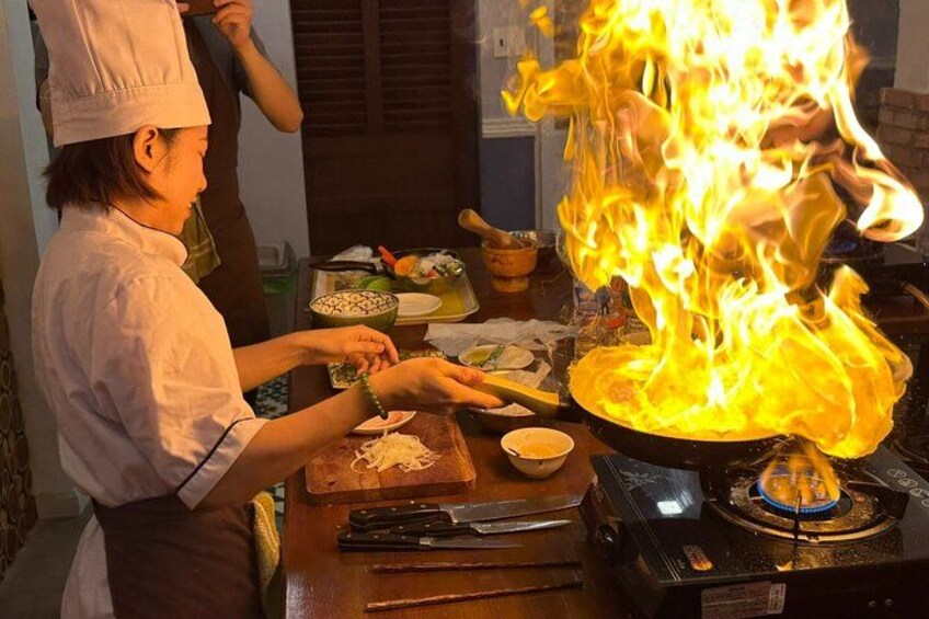 Un chef cuisinant avec des flammes sur une cuisinière. 2