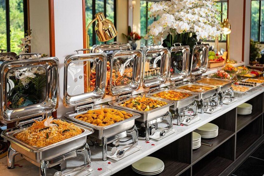A buffet with various food items in metal containers, arranged on a long table. 4