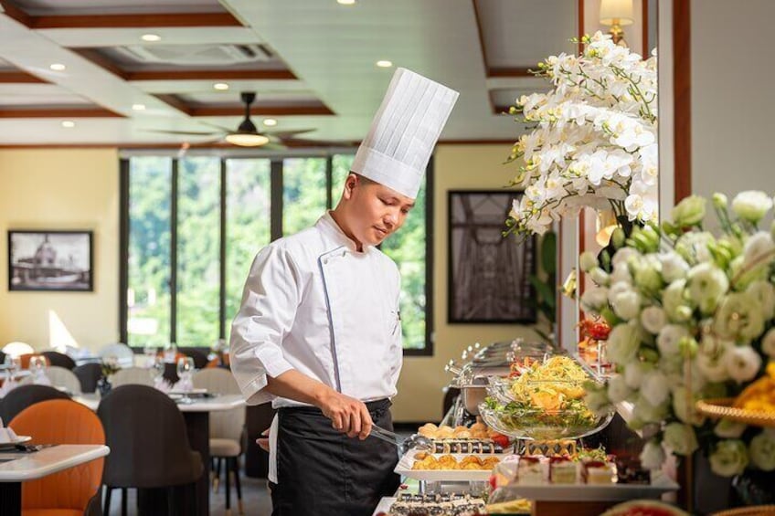 A chef in a white uniform and hat preparing food in a restaurant. 5