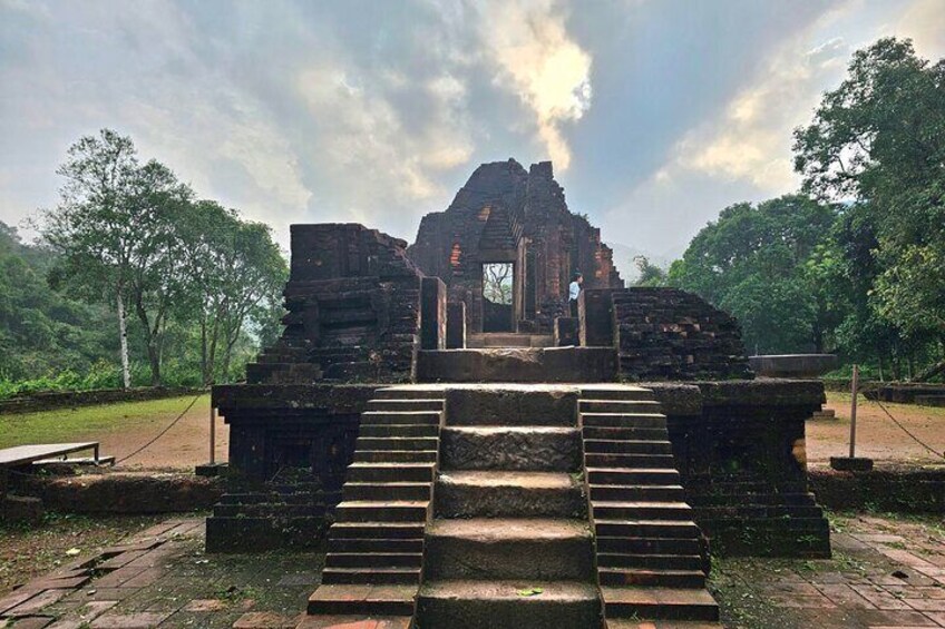 An ancient temple with stone steps leading up to a central structure. 2