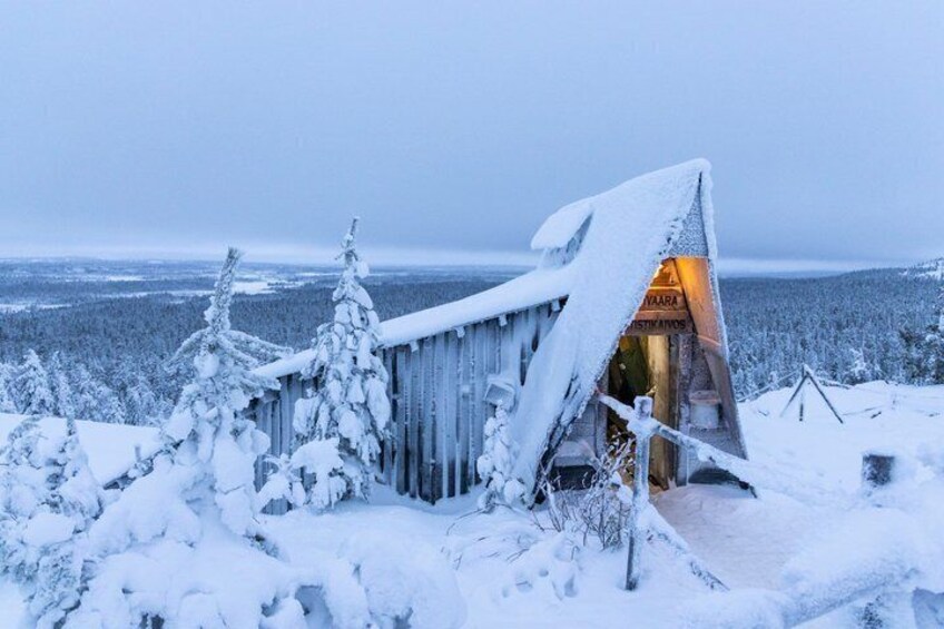 A snow-covered wooden structure with a sign that reads 'VAAARI.' 1