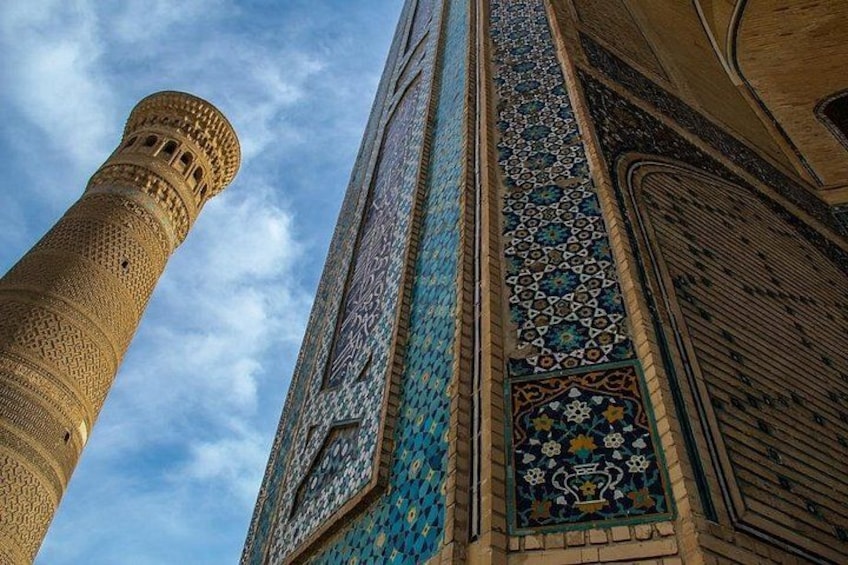 Un alto minareto con decorazioni elaborate e una moschea con piastrelle riccamente decorate. 3
