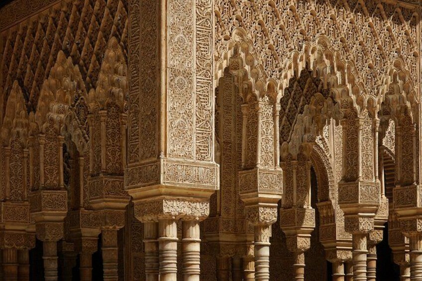 Feine architektonische Details eines historischen Gebäudes, mit verzierten Bögen und Säulen. 4