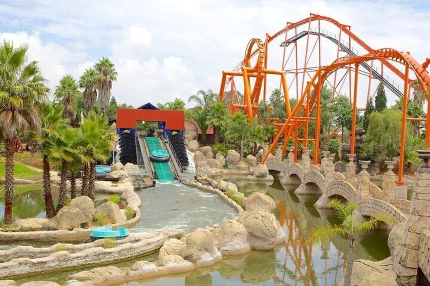 A water park with a roller coaster, a water slide, and a bridge. 2