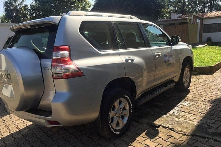 A silver SUV parked on a paved driveway. 1