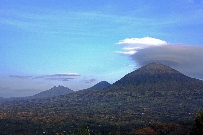 A mountain landscape with a prominent volcano and a smaller hill in the background. 4
