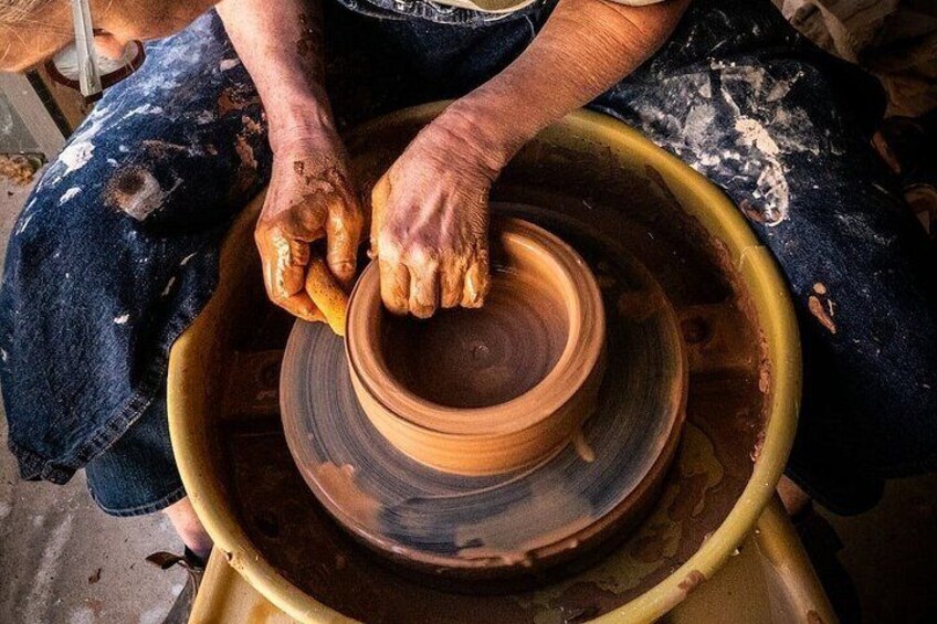 Mani che modellano un vaso di argilla su un tornio. 4